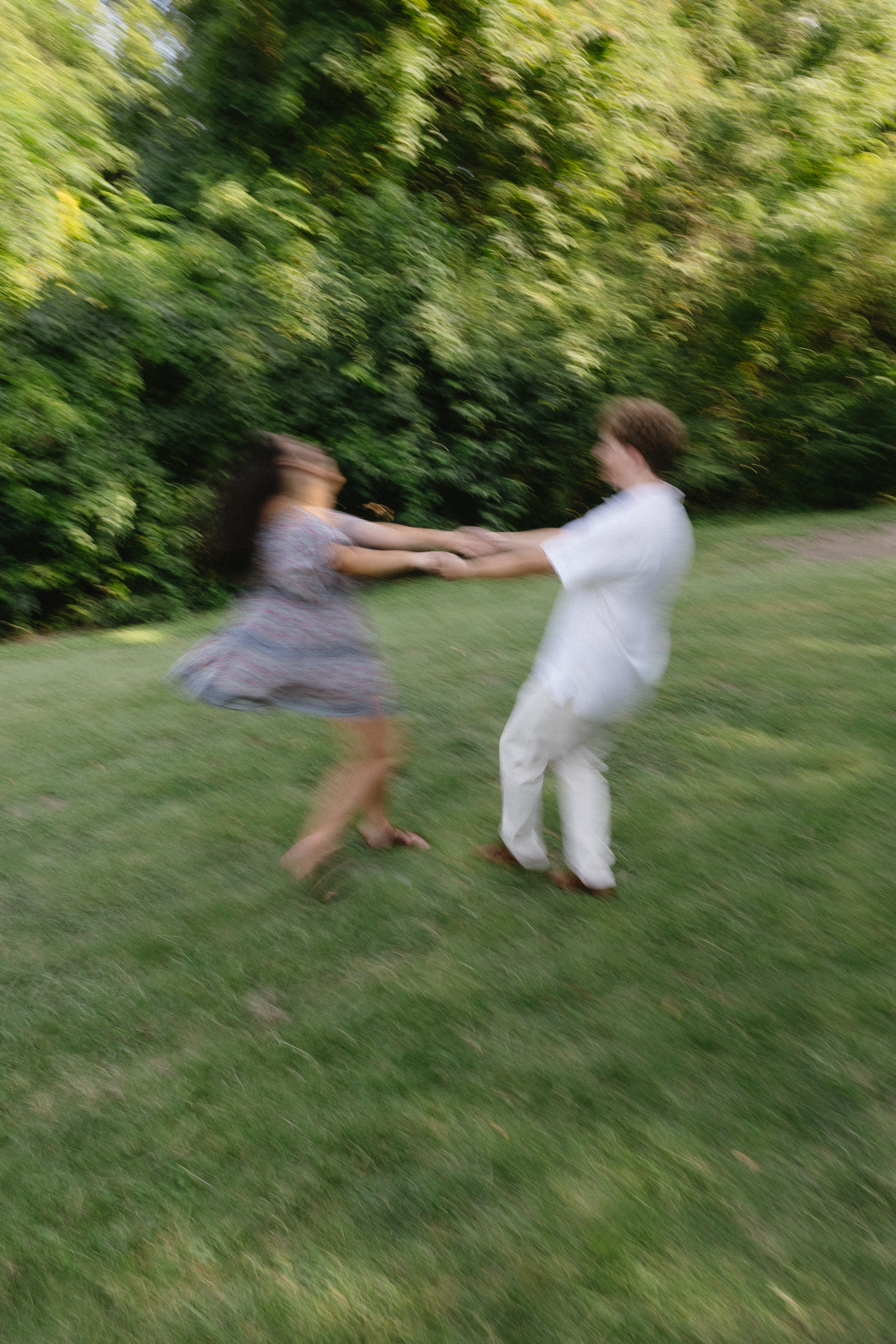 Couple spinning together on a lawn