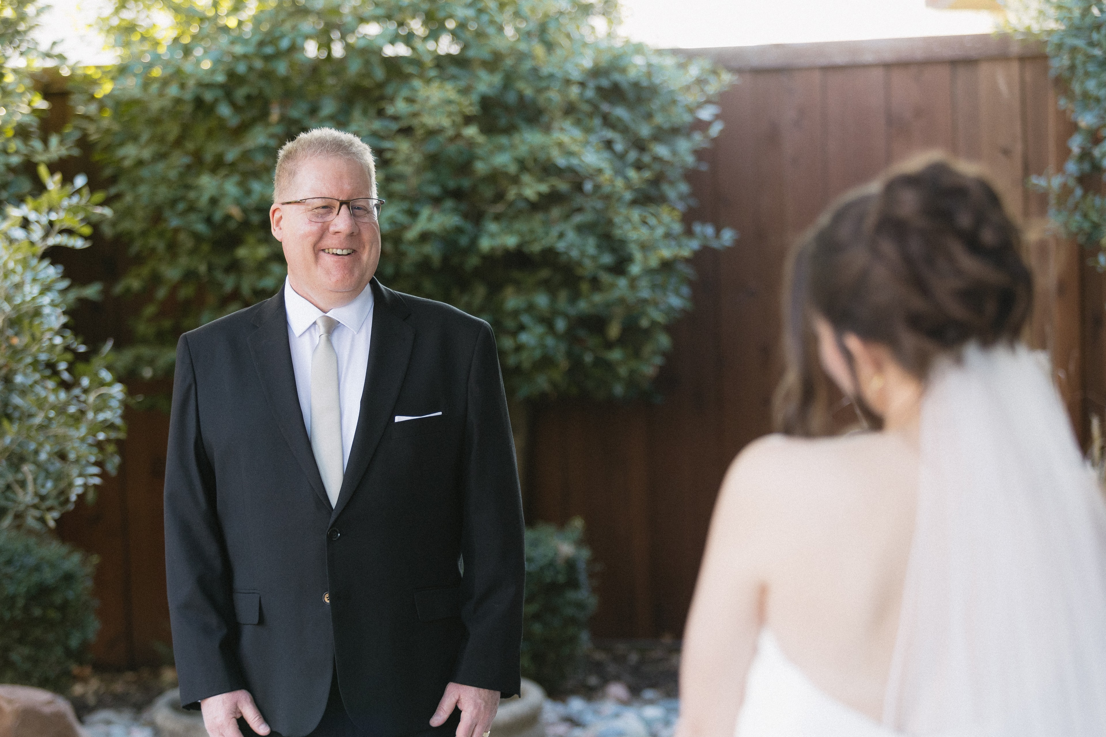 A bride approaching a man in a suit outdoors